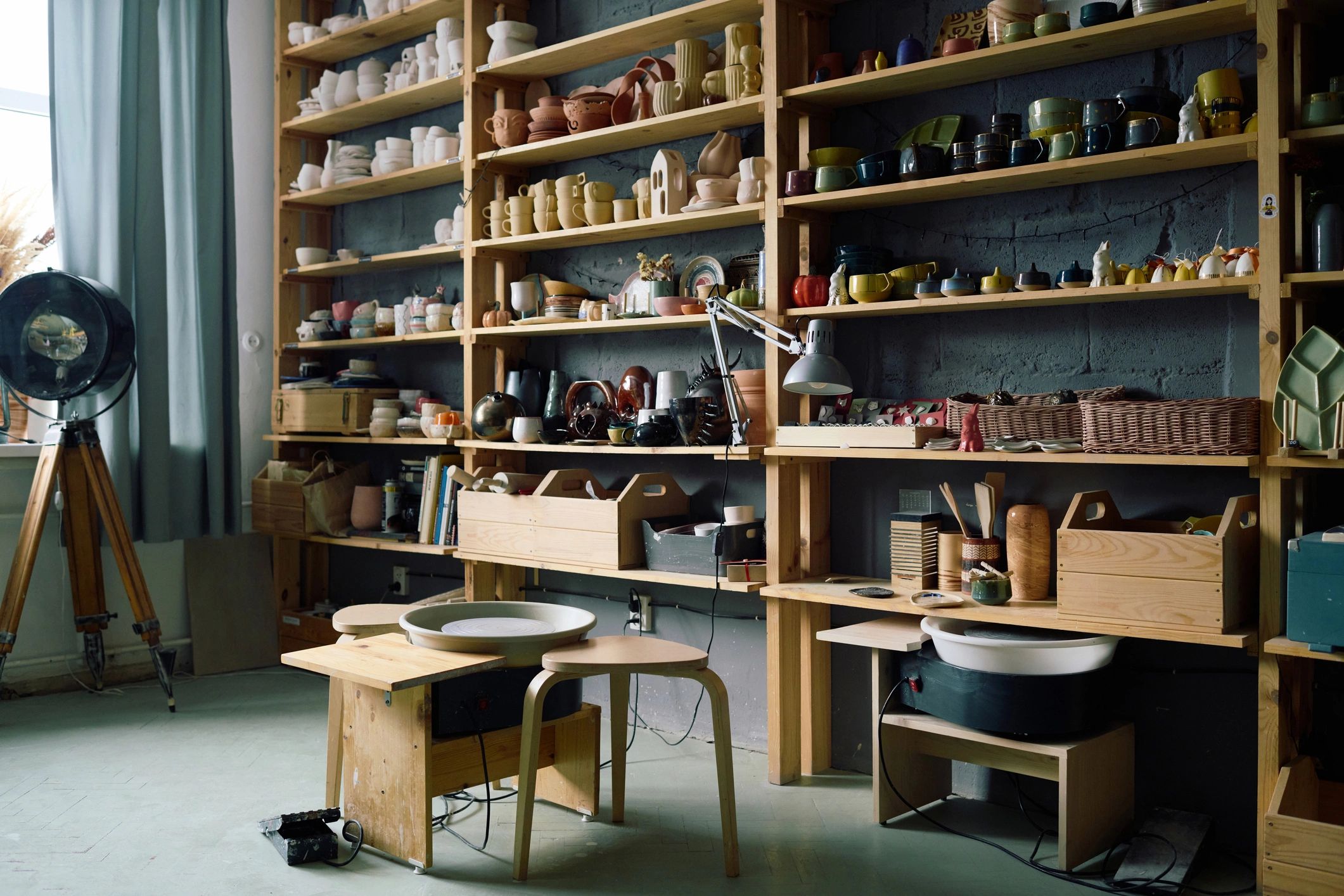 Pottery workshop interior with wheel and handmade pieces on shelves