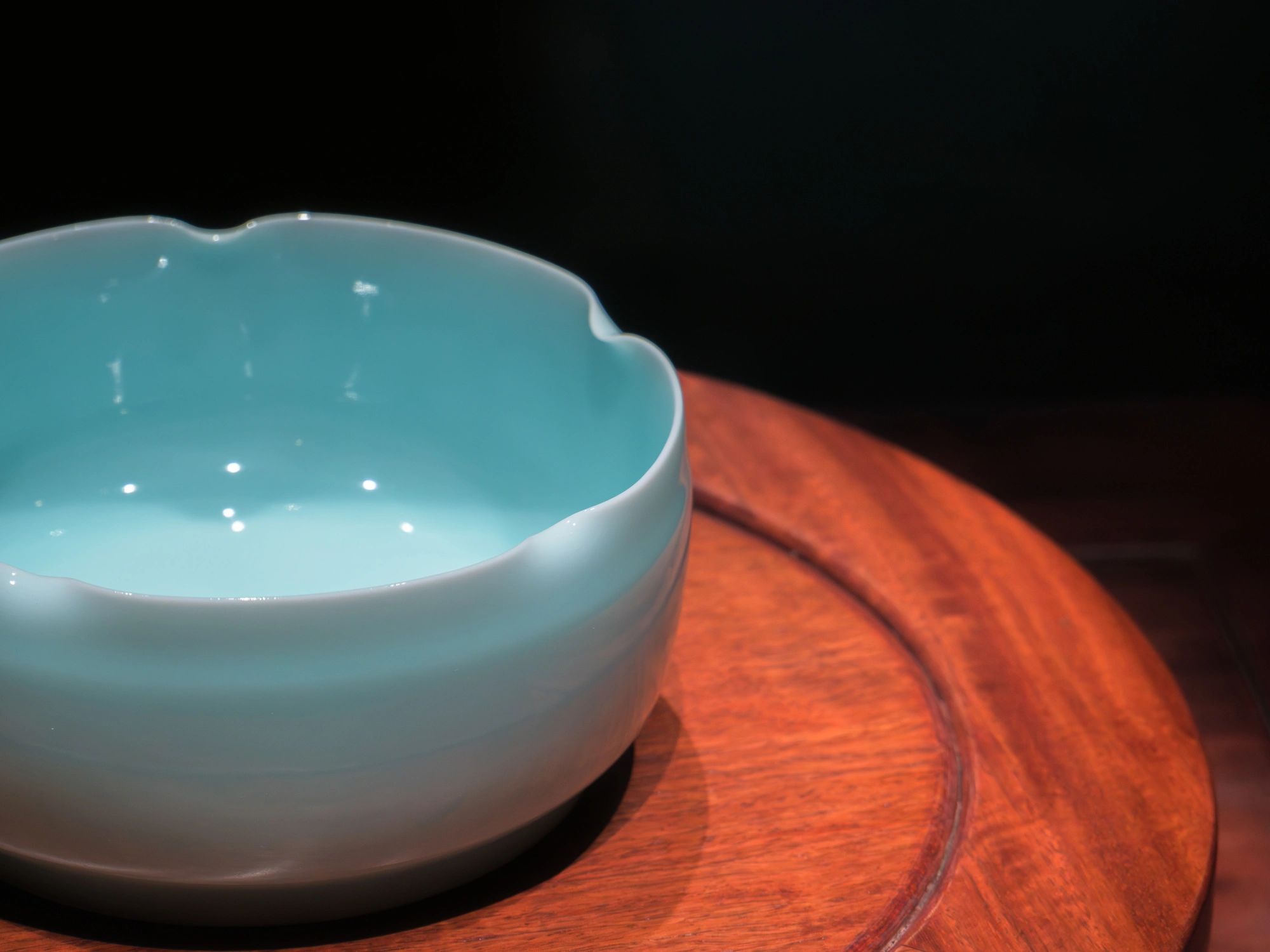 Elegant handcrafted ceramic bowl displayed on a wooden stand