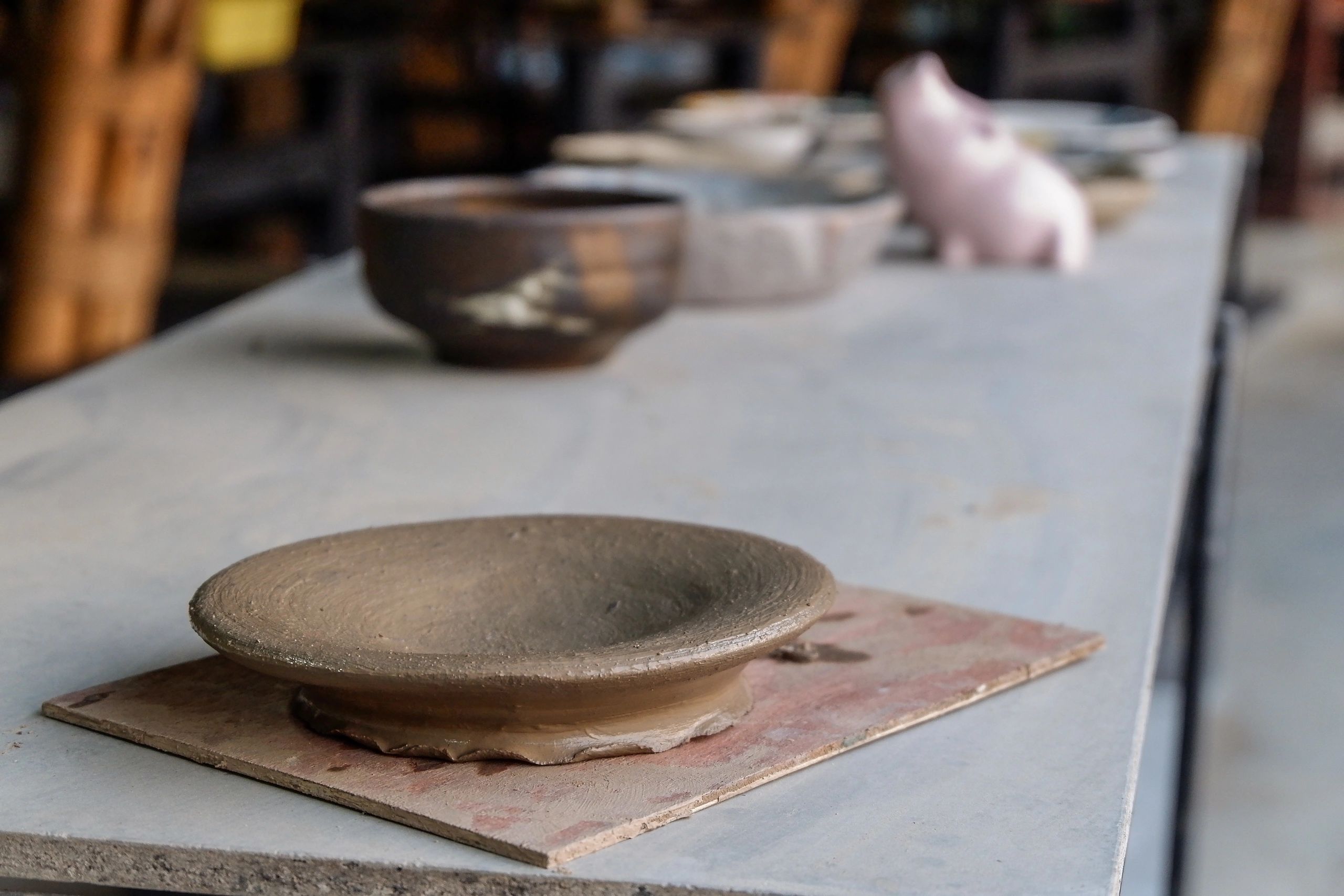 Handmade clay pottery drying on wooden table at craft studio
